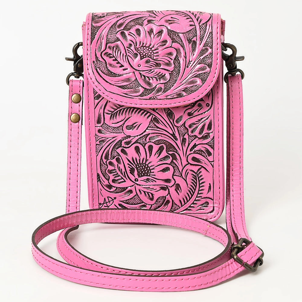 Pink leather crossbody bag with floral tooled design on a white background