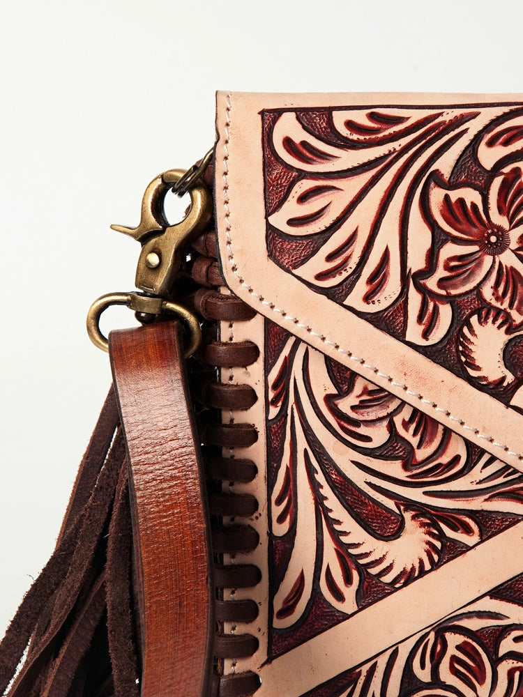 Leather bag with intricate floral patterns and a brown strap on a white background