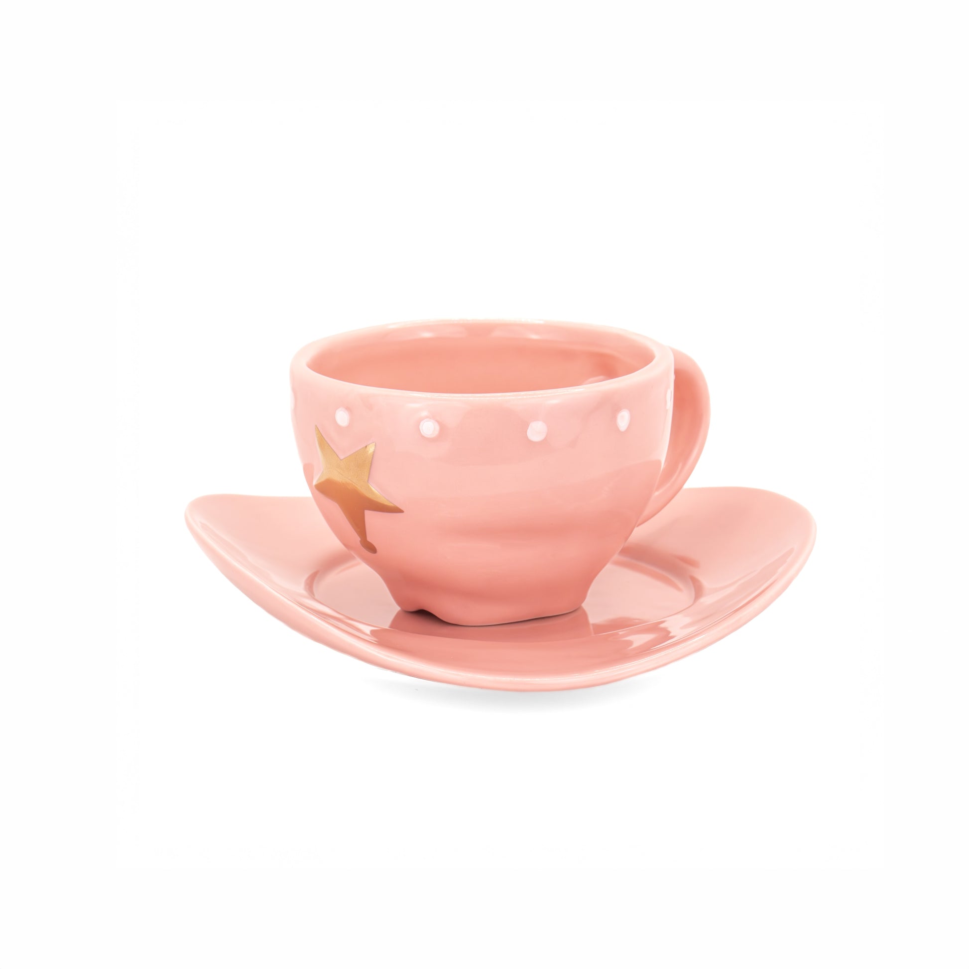 A pastel pink ceramic teacup and saucer set, featuring a small gold star decoration on the cup, set against a plain white background.