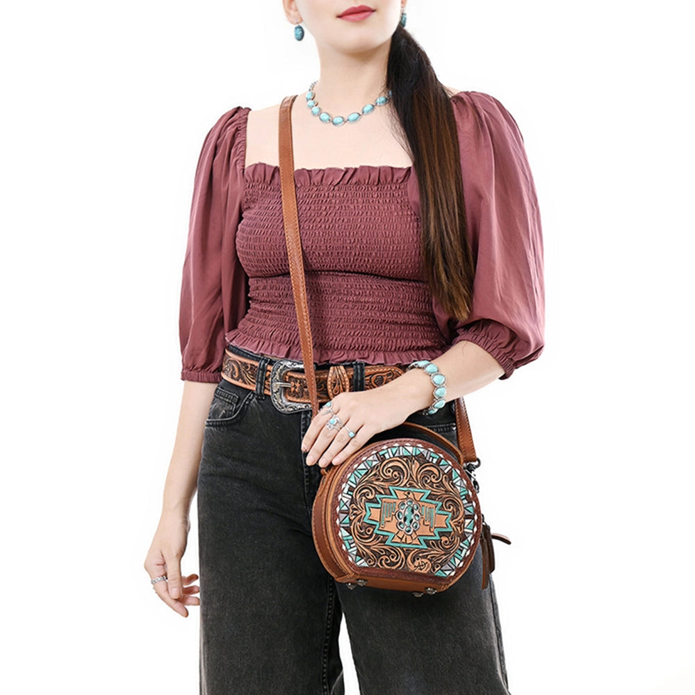 Woman holding a decorative brown handbag with intricate patterns on a white background