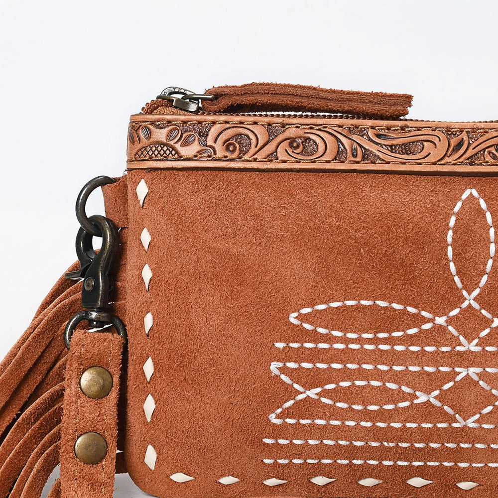 Brown leather handbag with intricate designs and tassels on a light gray background