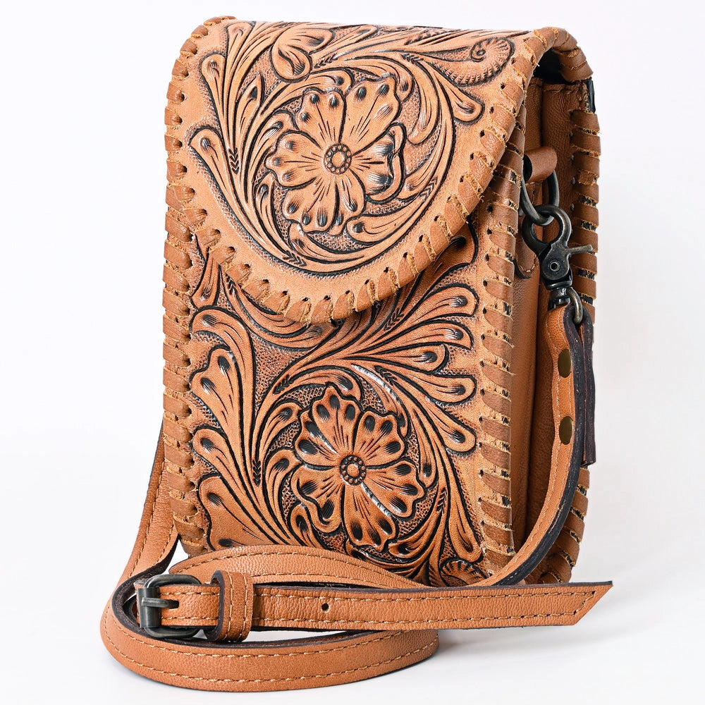 A tan leather crossbody bag with intricate floral tooling and braided leather trim, featuring a matching adjustable shoulder strap and black hardware, shown on a white background.