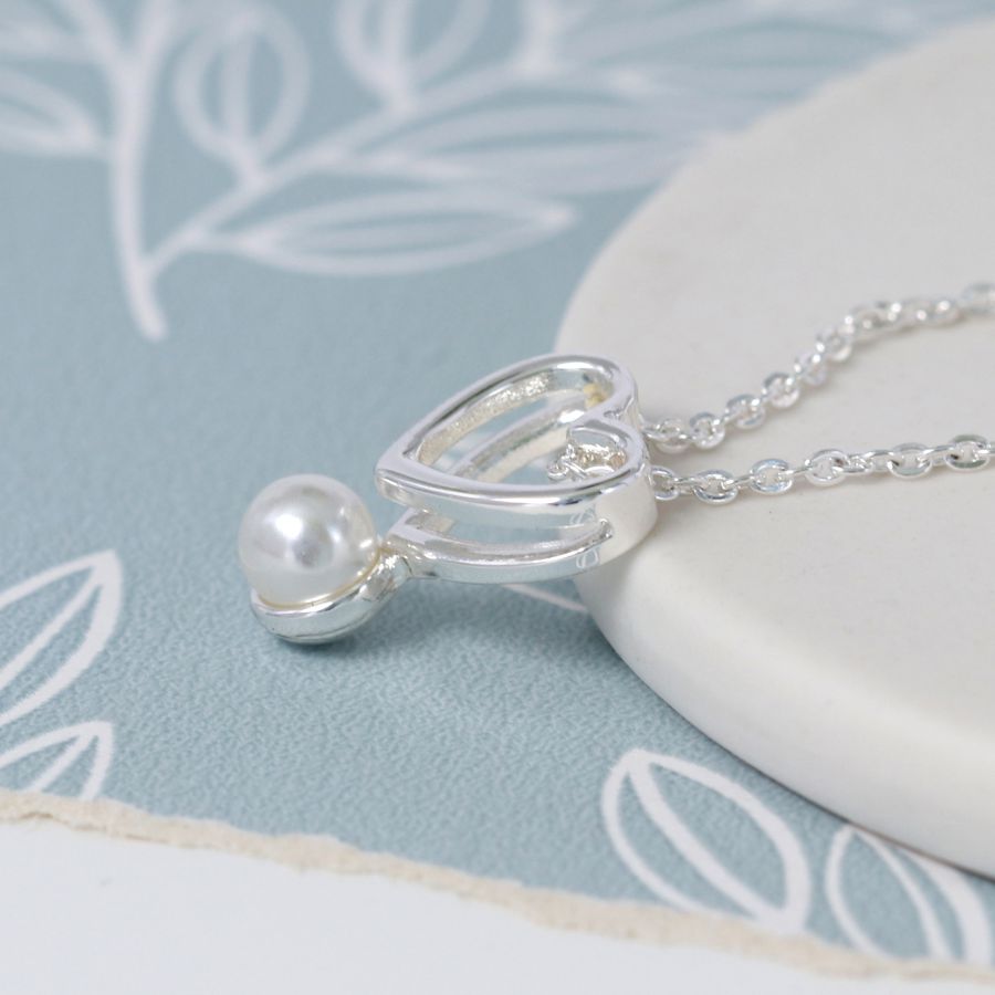 Fine chain silver plated necklace with a double layer open heart and a single white faux pearl