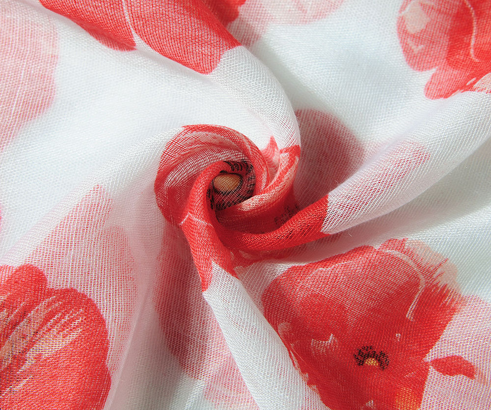 Close up A beautiful white scarf printed with a vibrant red poppy design.