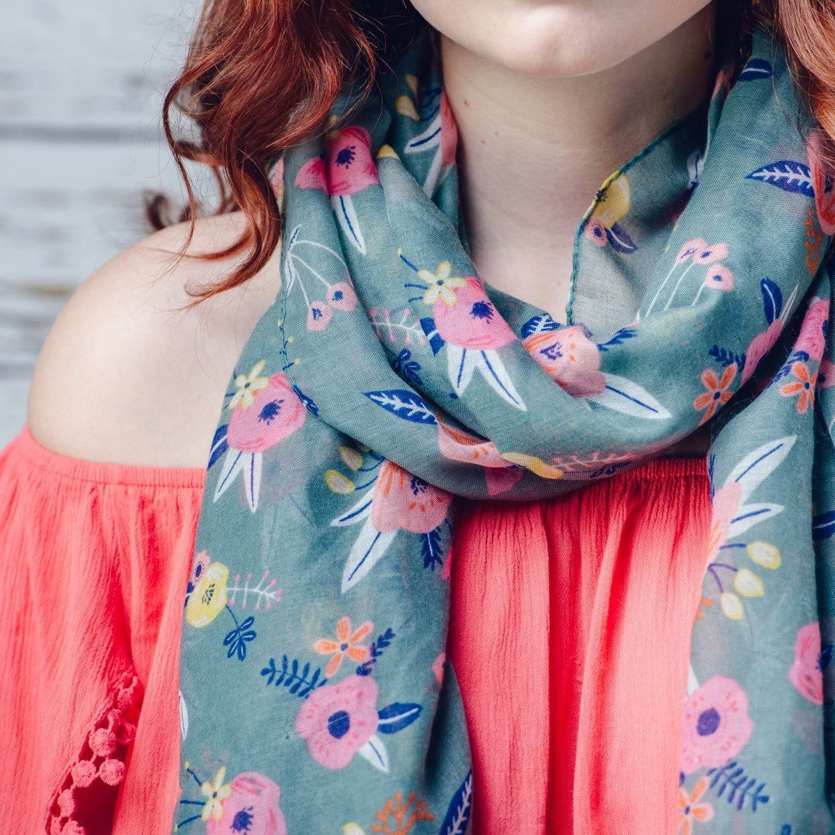 Delicate pastel pink flower printed scarf on a green background with feathered edge 