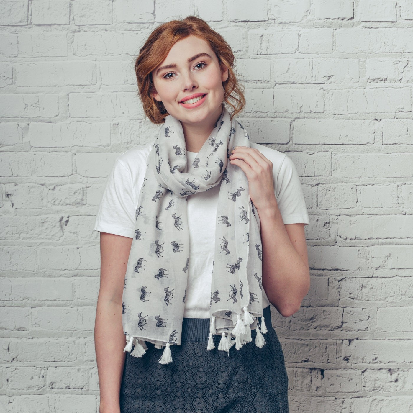 Zebra print on a white background with rolled and tassel edging. 